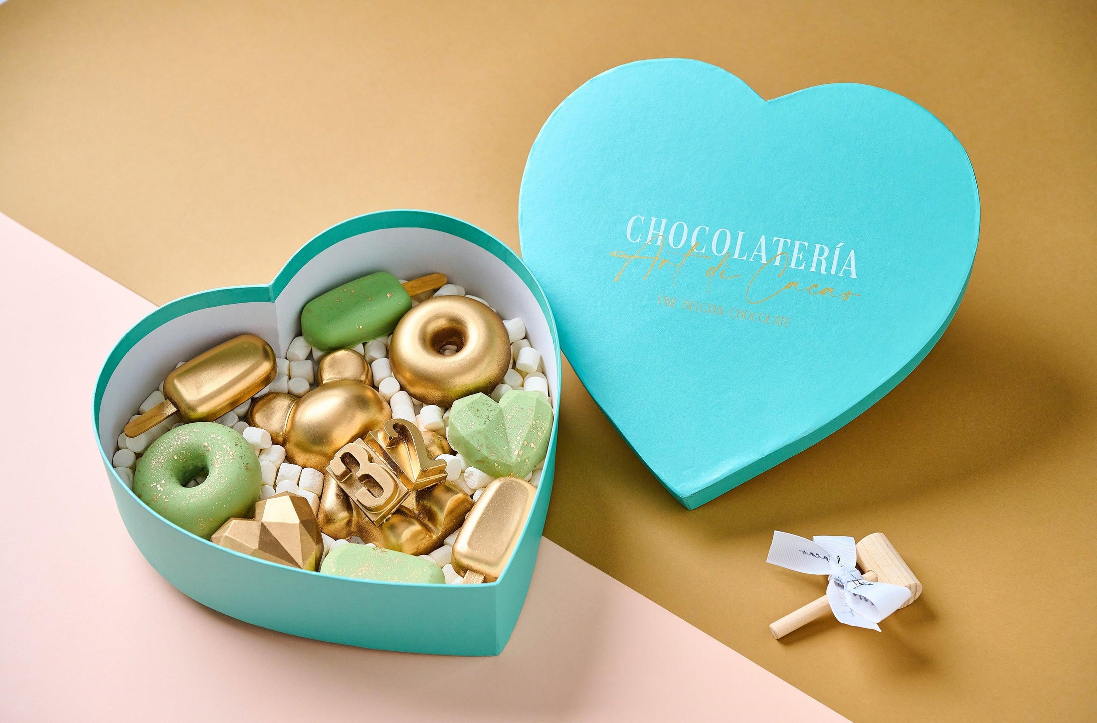 Chocolates para cumpleaños, caja en forma de corazón realizada con chocolate de leche y chocolate blanco. Vista de lado.