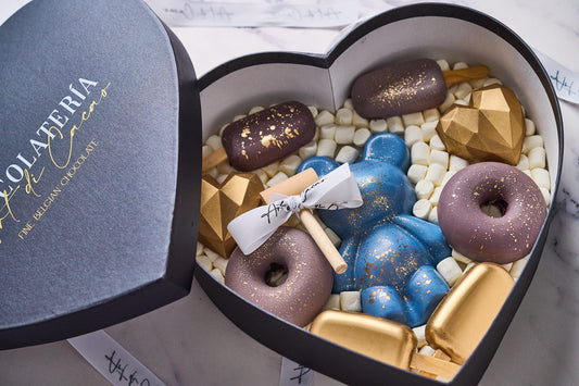 Chocolates para cumpleaños, caja en forma de corazón realizada con chocolate de leche y chocolate blanco. Vista de cerca.