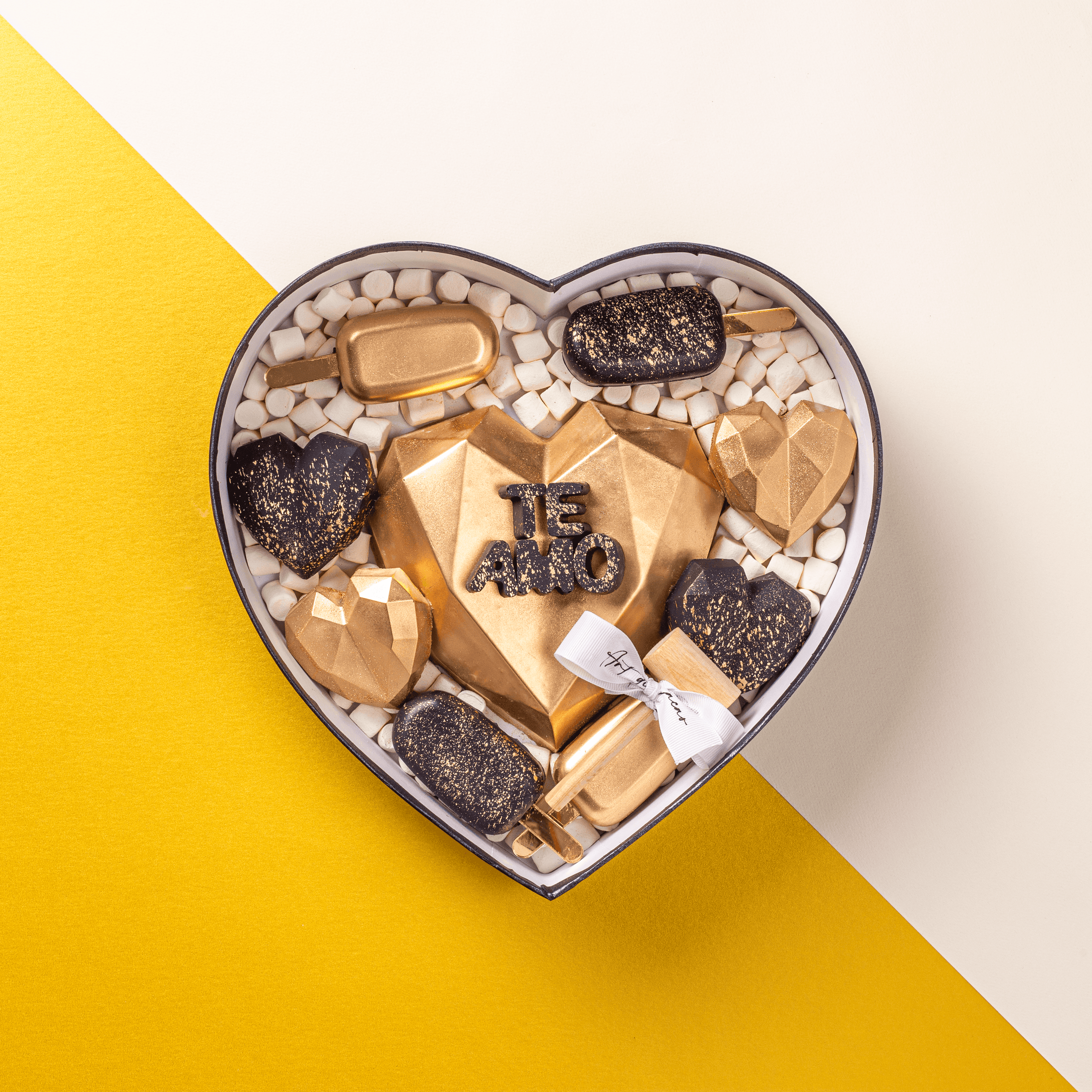 Chocolates para aniversario, caja en forma de corazón realizada con chocolate de leche y chocolate blanco. Vista de arriba.