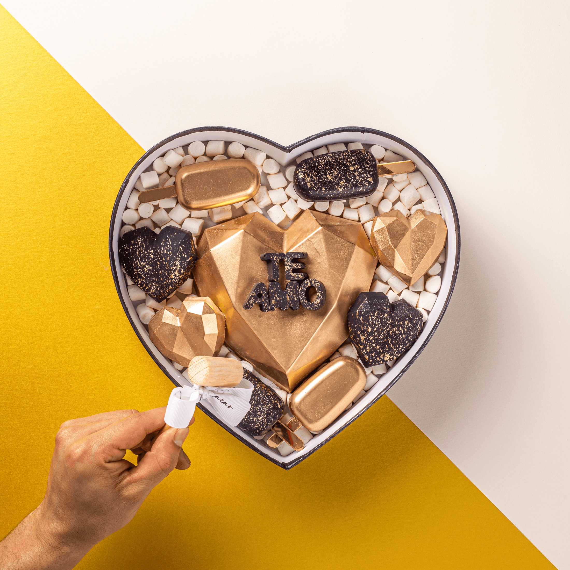 Chocolates para aniversario, caja en forma de corazón realizada con chocolate de leche y chocolate blanco. Interacción con producto. 