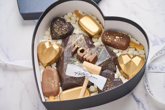 Chocolates para aniversario, caja en forma de corazón realizada con chocolate de leche y chocolate blanco. Vista de arriba.